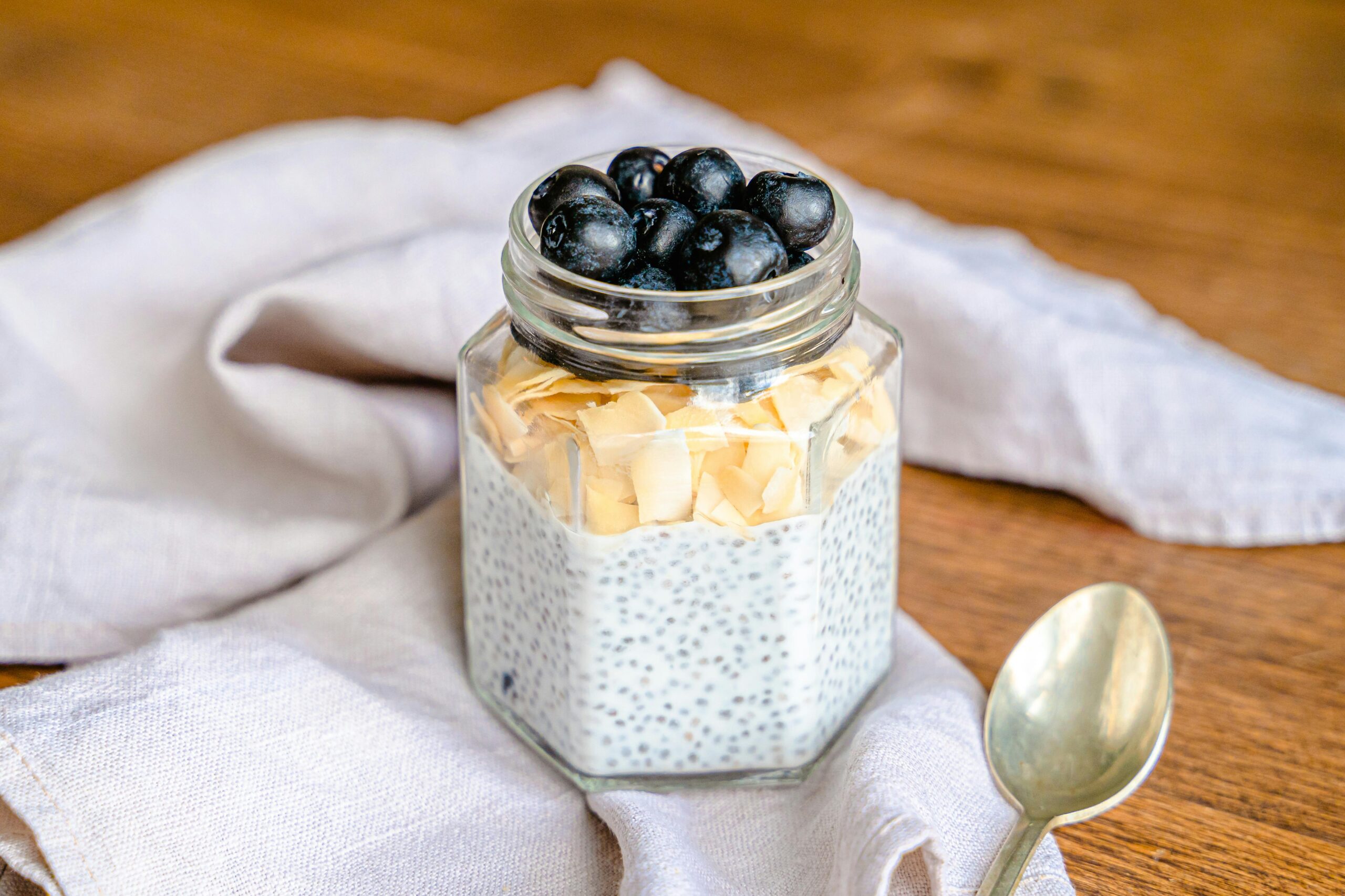 Delicious chia pudding topped with blueberries and almond flakes in a jar.