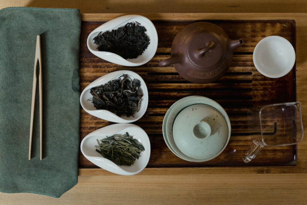 Artistic setup of a traditional Asian tea ceremony with cups, teapots, and tea leaves.